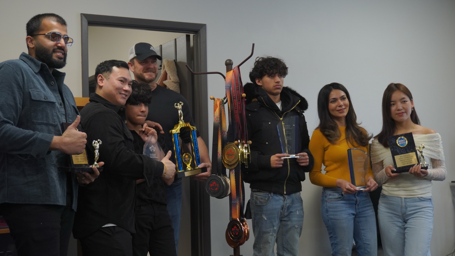 Team members celebrating with trophies and plaques