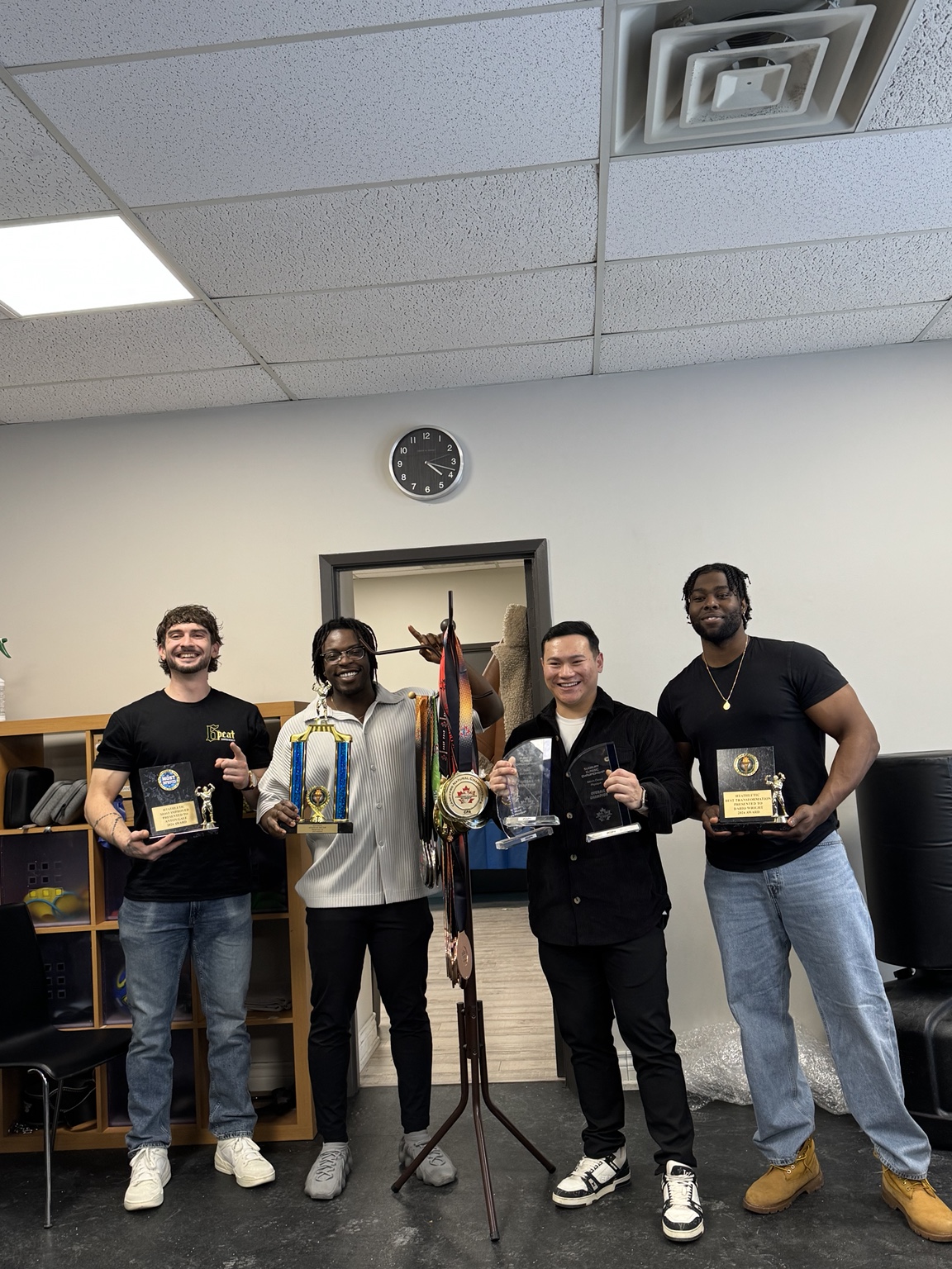 Team members celebrating with trophies and plaques